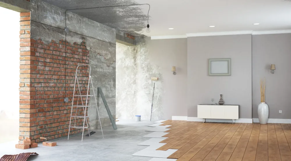 Stukadoor Amsterdam: woonruimte tijdens renovatie, links een ruwe bakstenen muur en rechts strak gestuukte en geschilderde wanden