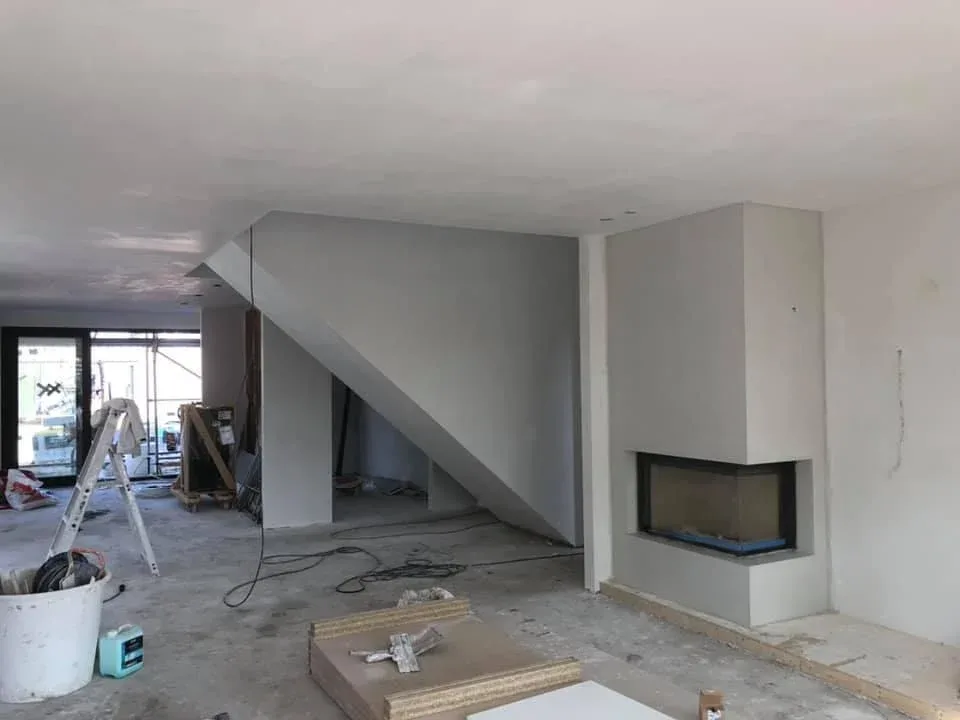 Sausklaar stucwerk op nieuw gestuukte wanden, plafond en schouw in een woning in afbouw