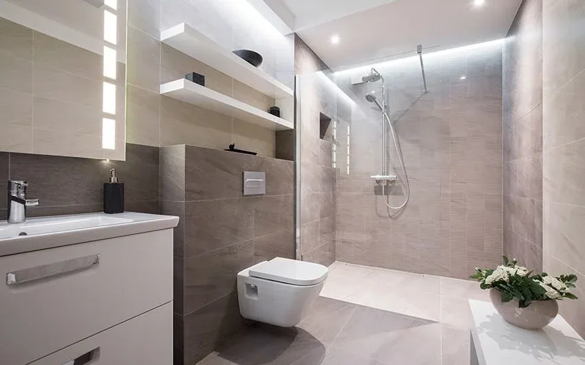 Badkamer met beige wandtegels, hangtoilet en inloopdouche met glazen wand